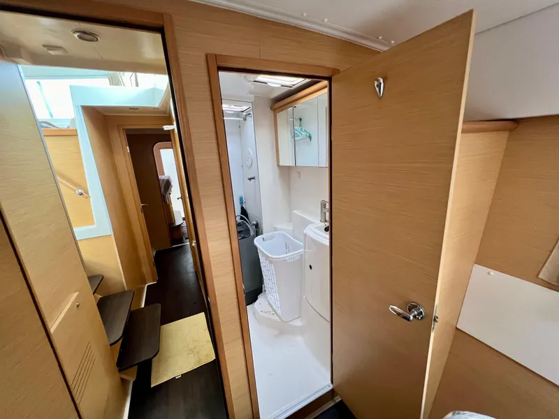 Slide: The Image of Interior of 2008 Lagoon 420 yacht, featuring a compact bathroom and wooden cabinetry. - 44