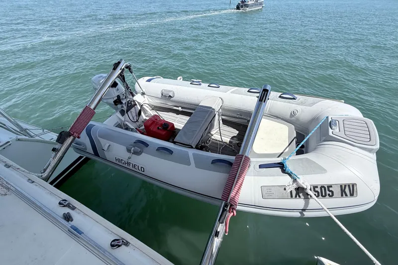 Slide: The Image of Inflatable dinghy attached to a 2008 Lagoon 420 catamaran on calm water. - 5