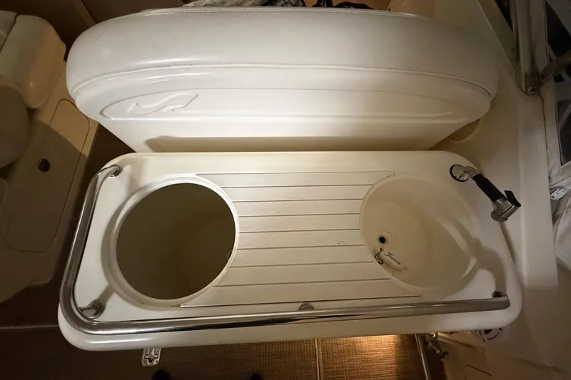 Slide: The Image of 2002 Sea Ray 290 Amberjack boat sink and storage area with faucet and compartments. - 5