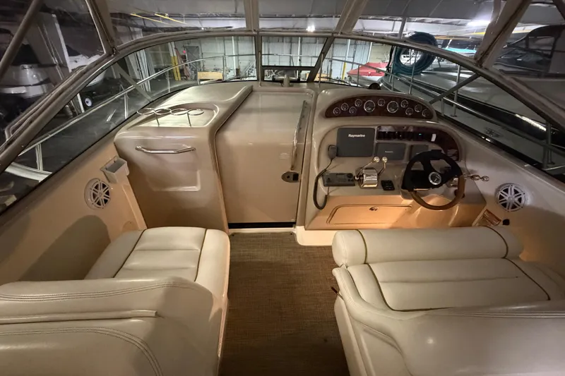 Slide: The Image of 2002 Sea Ray 290 Amberjack boat interior with helm, steering wheel, and seating. - 6