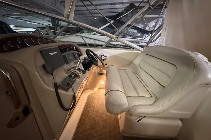 Slide: The Image of 2002 Sea Ray 290 Amberjack helm with beige leather seating and navigation equipment. - 8