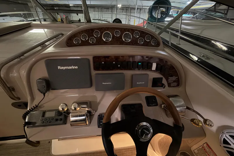 Slide: The Image of 2002 Sea Ray 290 Amberjack helm with Raymarine electronics and wooden steering wheel. - 9