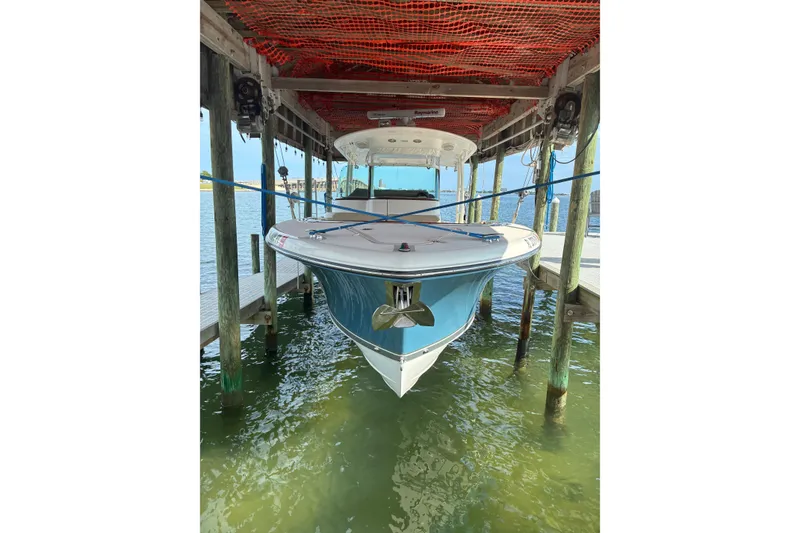 The Image of 2015 Pursuit ST 310 Sport boat docked under a wooden shelter. - 0
