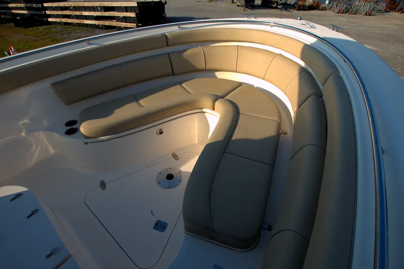 Slide: The Image of 2015 Pursuit ST 310 Sport boat with beige cushioned seating in the bow area. - 34