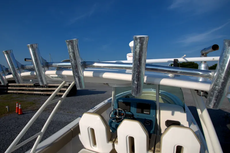 Slide: The Image of 2015 Pursuit ST 310 Sport boat cockpit with rod holders under clear blue sky. - 40