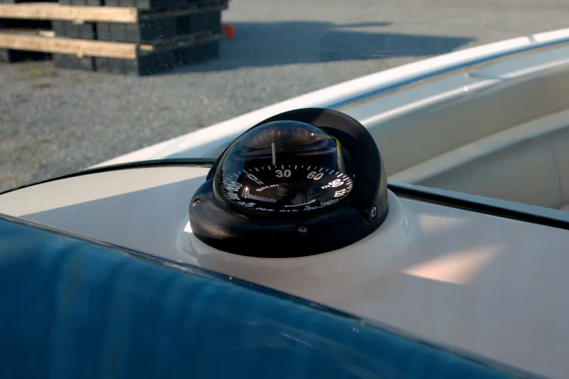Slide: The Image of Compass on 2015 Pursuit ST 310 Sport boat dashboard, close-up view. - 47