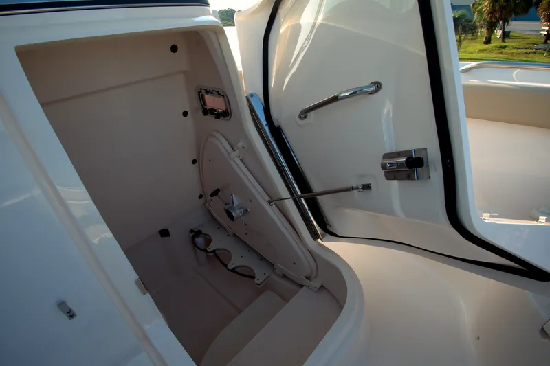 Slide: The Image of 2015 Pursuit ST 310 Sport boat interior storage compartment with open door. - 23
