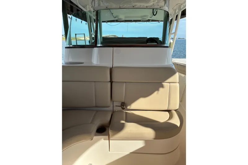 Slide: The Image of 2015 Pursuit ST 310 Sport boat interior with cushioned seating and covered console. - 6