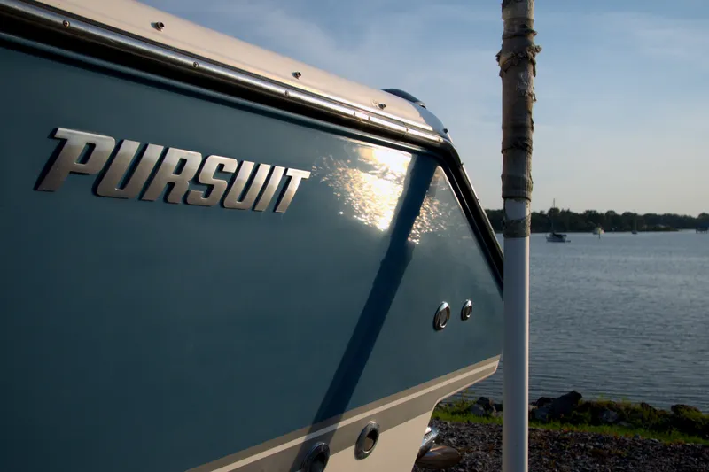 Slide: The Image of 2015 Pursuit ST 310 Sport boat by the water at sunset. - 25