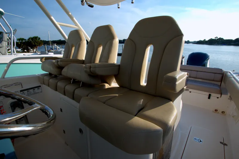 Slide: The Image of Luxurious seating on a 2015 Pursuit ST 310 Sport boat, overlooking a serene waterfront. - 18