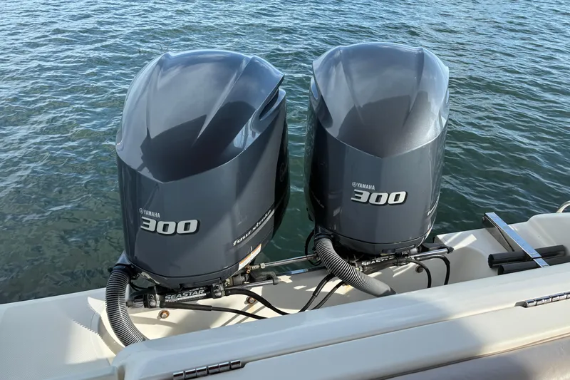 Slide: The Image of 2015 Pursuit ST 310 Sport boat interior with cushioned seating, dockside view. - 9