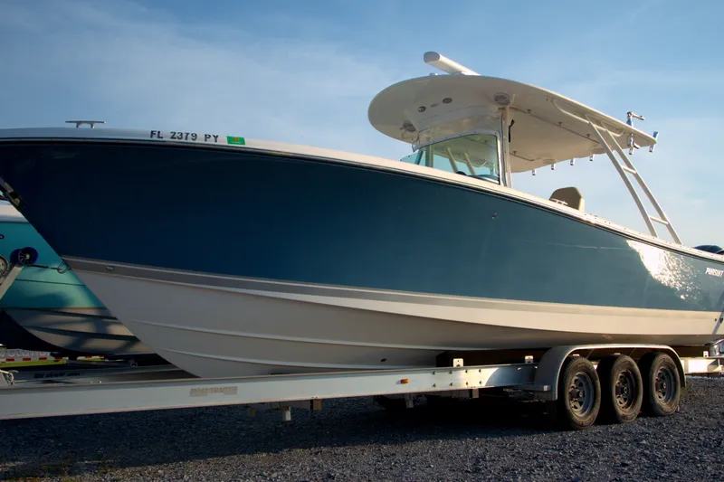 Slide: The Image of 2015 Pursuit ST 310 Sport boat on trailer, side view, blue and white design. - 31