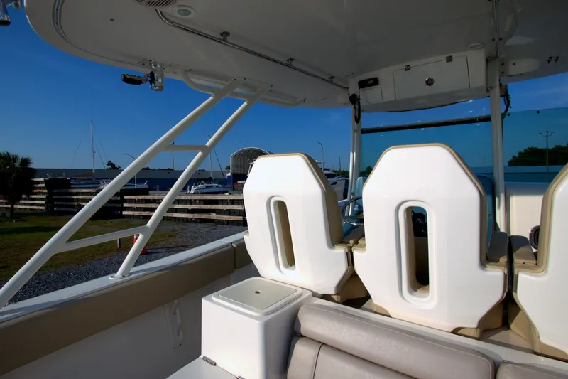 Slide: The Image of 2015 Pursuit ST 310 Sport boat interior with seating and helm, docked at marina. - 41