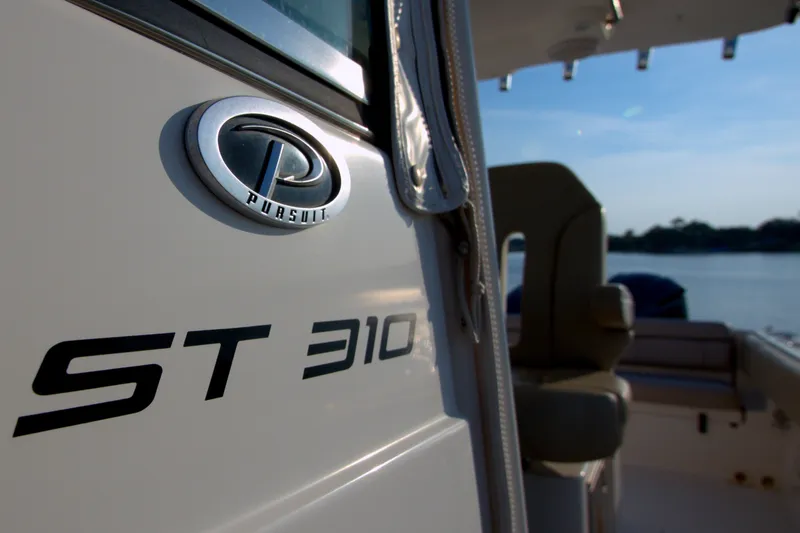 Slide: The Image of 2015 Pursuit ST 310 Sport boat, close-up of logo and seating area. - 36