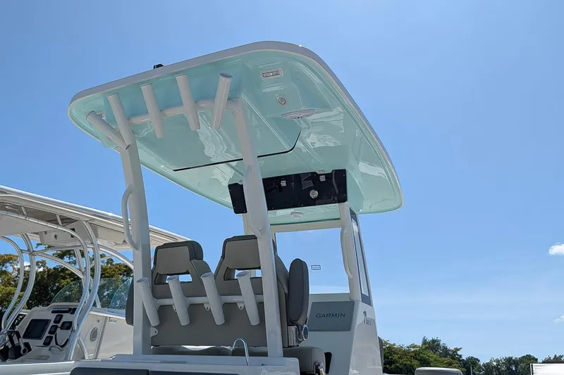 Slide: The Image of 2026 Key West 249 FS boat with T-top and seating under clear blue sky. - 26