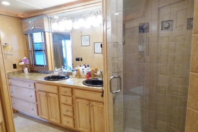 Slide: The Image of Luxurious bathroom in a 2009 Sumerset 19x105 houseboat with dual sinks and glass shower. - 13