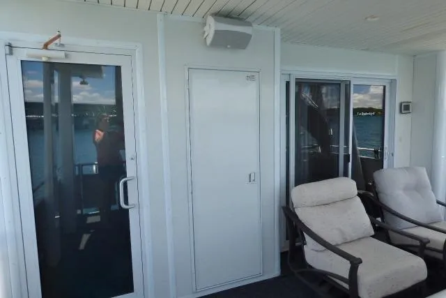 Slide: The Image of 2009 Sumerset 19x105 houseboat deck with sliding glass doors and cushioned chairs. - 14