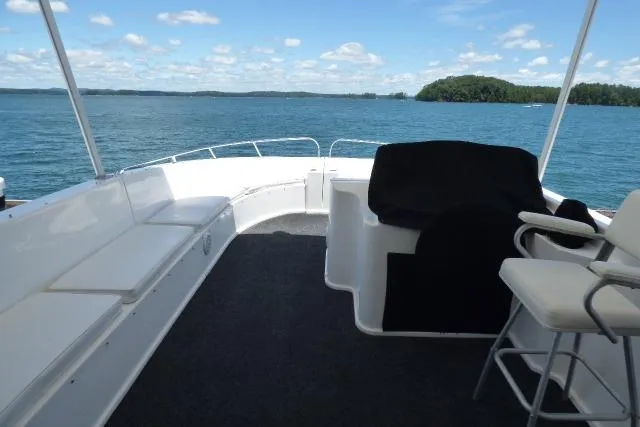 Slide: The Image of 2009 Sumerset 19x105 houseboat deck with seating, overlooking serene lake and blue sky. - 16