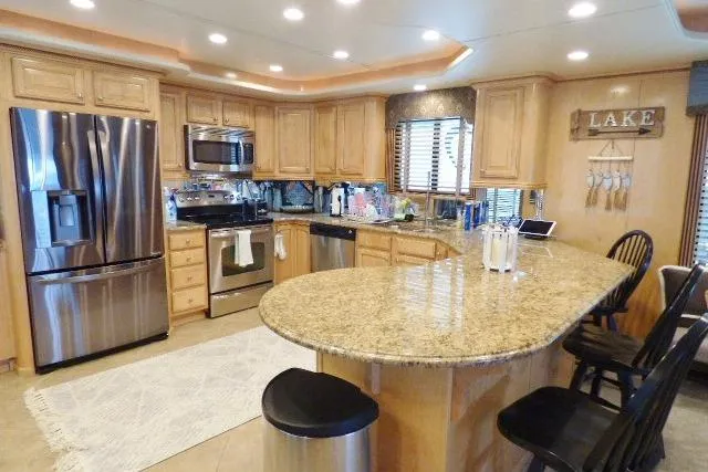 Slide: The Image of Luxurious 2009 Sumerset 19x105 houseboat kitchen with granite countertops and stainless steel appliances. - 4