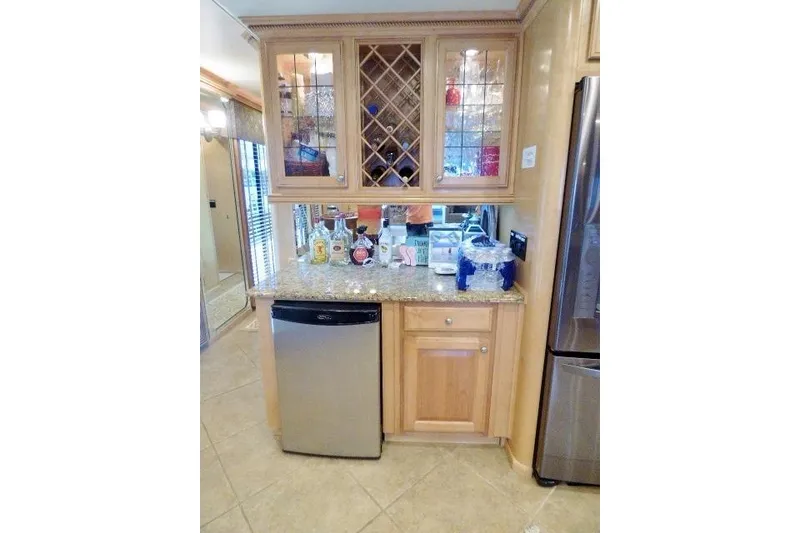 Slide: The Image of Kitchen area in a 2009 Sumerset 19x105 houseboat with wooden cabinets and mini fridge. - 5