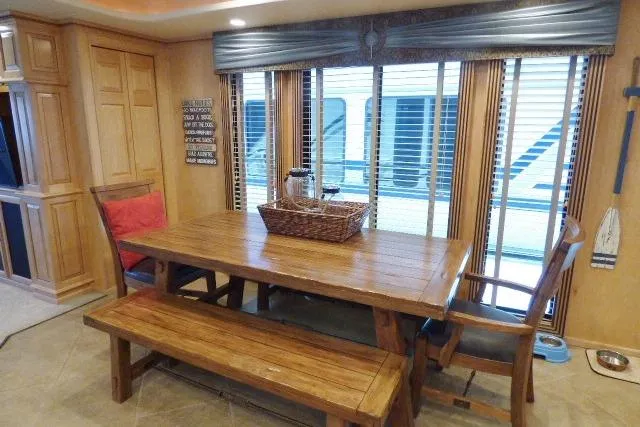 Slide: The Image of Dining area in a 2009 Sumerset 19x105 houseboat with wooden table and bench seating. - 6