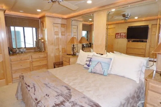 Slide: The Image of Luxurious bedroom interior in a 2009 Sumerset 19x105 houseboat, featuring elegant wood furnishings. - 7