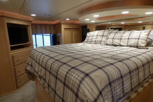 Slide: The Image of Luxurious bedroom interior of 2009 Sumerset 19x105 houseboat with plaid bedding and ambient lighting. - 9