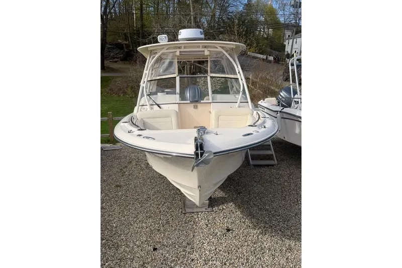 Slide: The Image of 2012 Grady-White Freedom 235 boat on gravel, front view, with trees in background. - 3