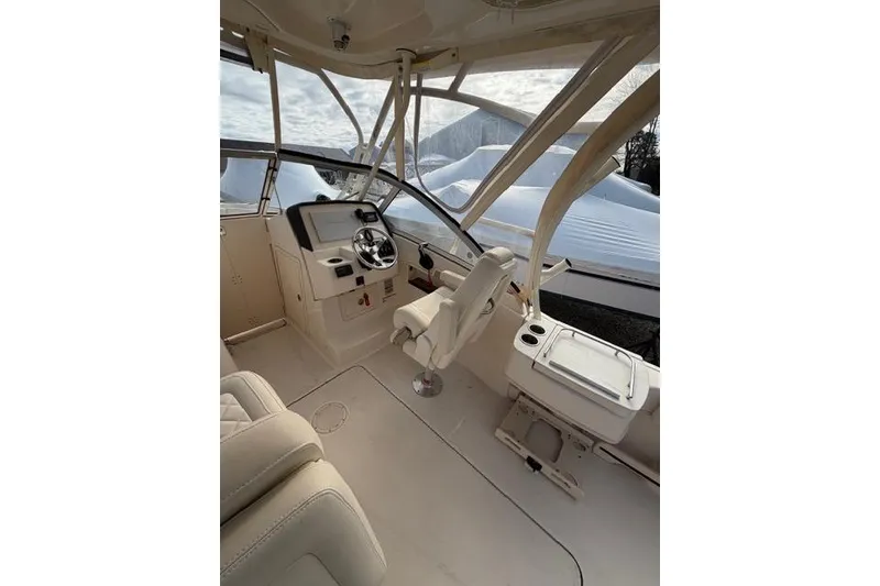 Slide: The Image of Interior of a 2012 Grady-White Freedom 235 boat, featuring helm and seating area. - 7