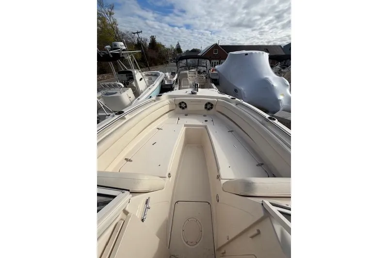 Slide: The Image of 2012 Grady-White Freedom 235 boat interior with seating and storage, docked outdoors. - 9