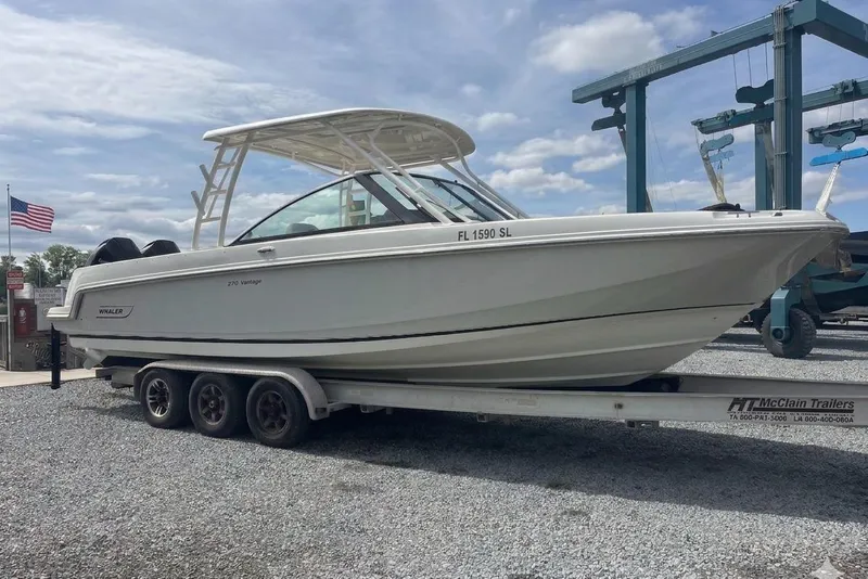 The Image of 2019 Boston Whaler 270 Vantage boat on trailer, parked outdoors under cloudy sky. - 1