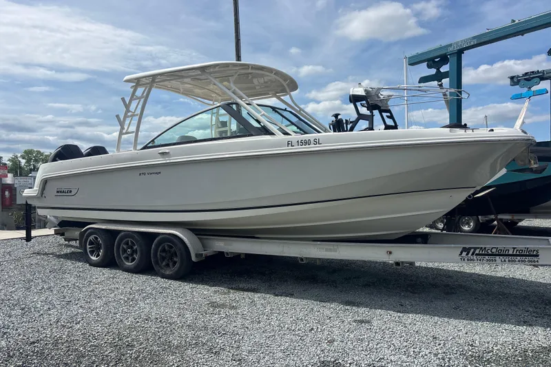 Slide: The Image of 2019 Boston Whaler 270 Vantage boat on trailer, parked outdoors under a cloudy sky. - 3