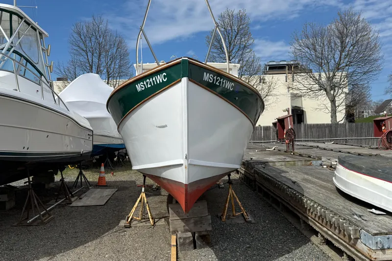 Slide: The Image of 2024 Hylan Bowler boat on stands in a boatyard, surrounded by other vessels. - 10