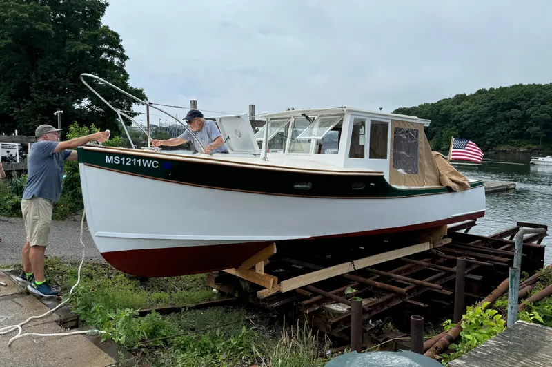 Slide: The Image of 2024 Hylan Bowler boat being prepared for launch at a scenic waterfront. - 15