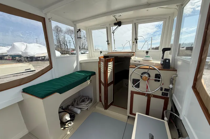 Slide: The Image of 2024 Hylan Bowler boat interior with steering wheel, seating, and storage compartments. - 18
