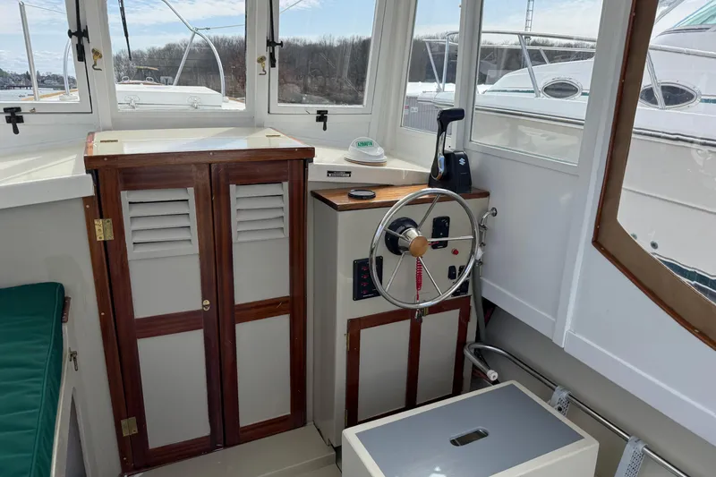 Slide: The Image of 2024 Hylan Bowler boat interior with steering wheel and wooden cabinetry. - 19