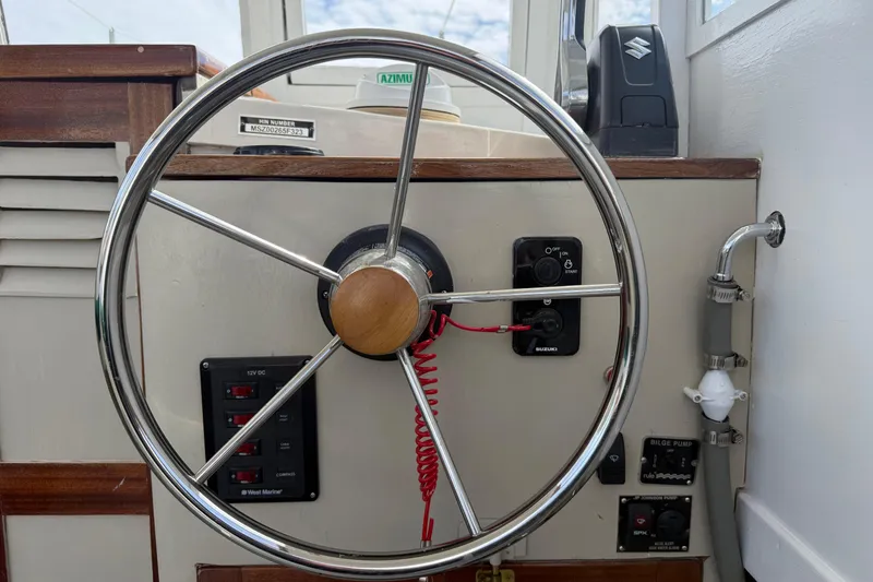 Slide: The Image of Steering wheel of 2024 Hylan Bowler boat with control panel and switches. - 20