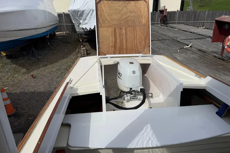 Slide: The Image of 2024 Hylan Bowler boat with Suzuki outboard motor in a storage yard. - 25