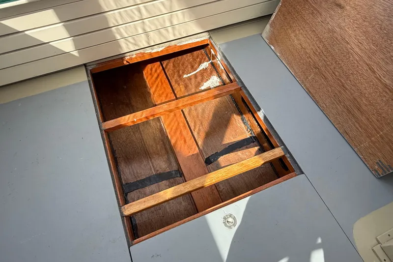Slide: The Image of Open wooden hatch on a 2024 Hylan Bowler boat deck, revealing storage space. - 45