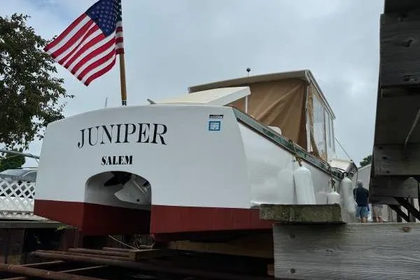 Slide: The Image of 2024 Hylan Bowler boat named "Juniper" in Salem, docked with American flag. - 5