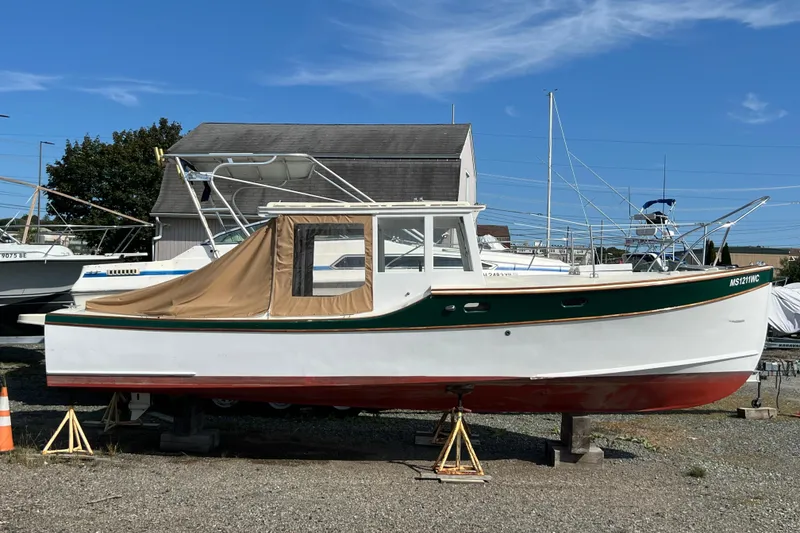 Slide: The Image of 2024 Hylan Bowler boat on display, featuring a green and white exterior with a tan cover. - 8