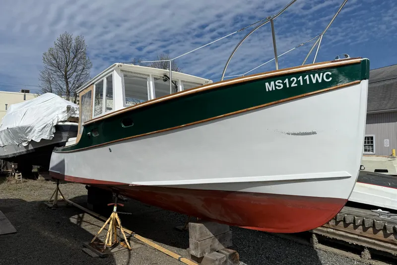 Slide: The Image of 2024 Hylan Bowler boat on stands, green and white hull, registration MS1211WC. - 9