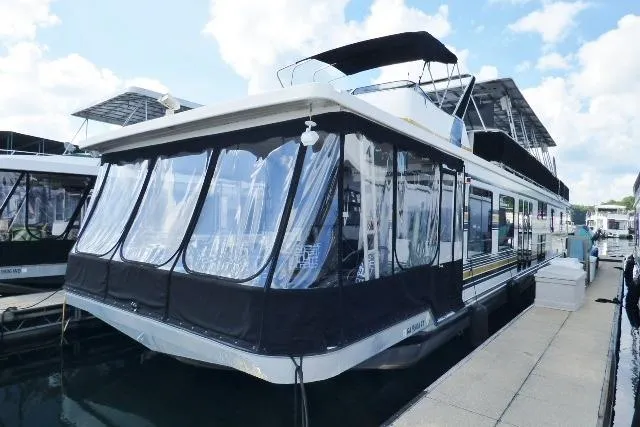 The Image of 1997 Sumerset 16x80 houseboat docked at marina under clear skies. - 0