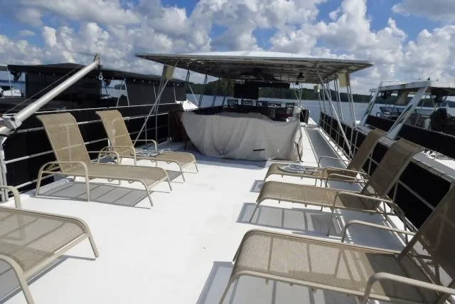 Slide: The Image of 1997 Sumerset 16x80 houseboat deck with lounge chairs under a blue sky. - 13