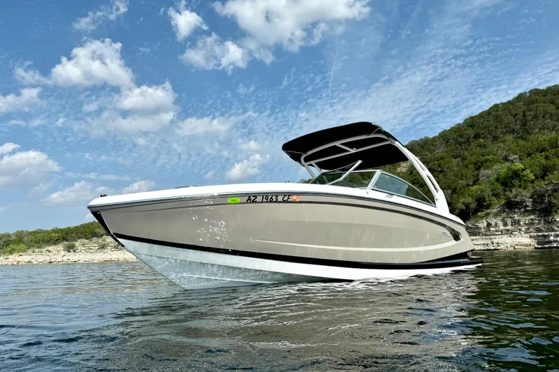 Slide: The Image of 2013 Cobalt A25 boat on water, clear sky, rocky shoreline background. - 10