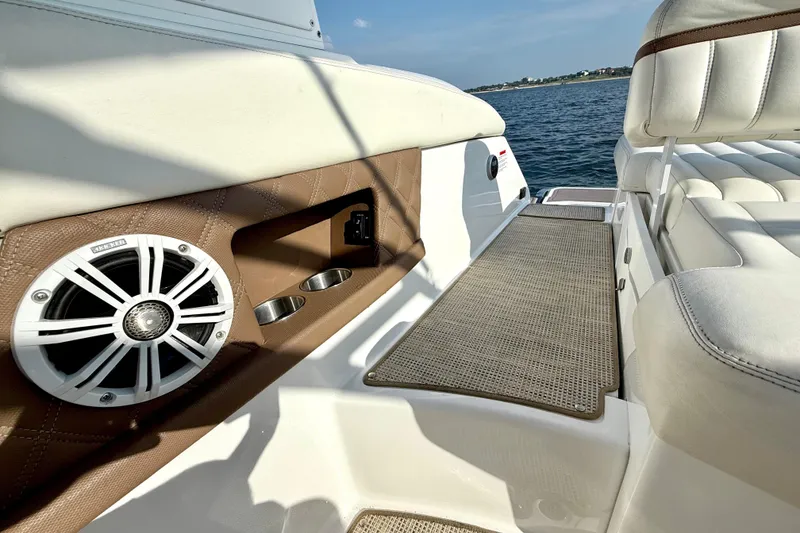 Slide: The Image of Interior of 2013 Cobalt A25 boat with speaker and seating, overlooking water. - 25