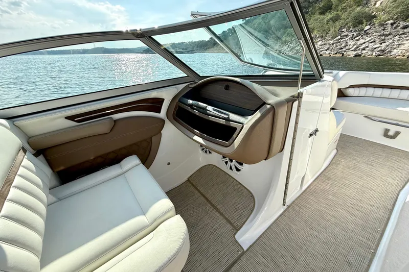Slide: The Image of Interior of a 2013 Cobalt A25 boat with luxurious seating and scenic water view. - 26