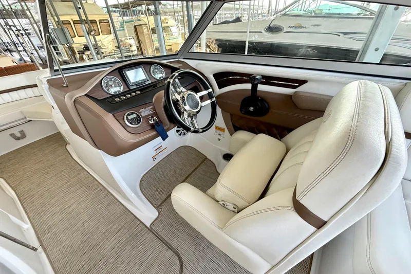 Slide: The Image of Interior of a 2013 Cobalt A25 boat featuring a sleek steering console and plush seating. - 30