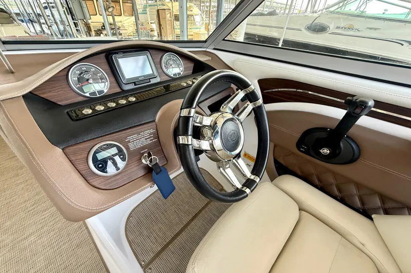 Slide: The Image of Interior of a 2013 Cobalt A25 boat featuring a sleek dashboard and steering wheel. - 32