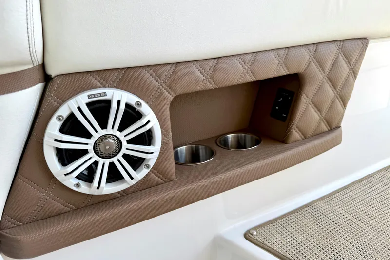 Slide: The Image of 2013 Cobalt A25 boat interior with speaker, cup holders, and quilted leather paneling. - 34